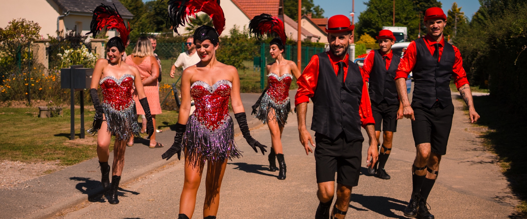 Une déambulation élégante des années folles avec danseurs Charleston. Voiture vintage, rouge et noir pour une expérience rétro-chic.